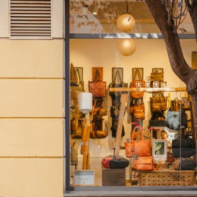 Elegant handbag store display in Barcelona, featuring a variety of stylish bags through a large glass window.