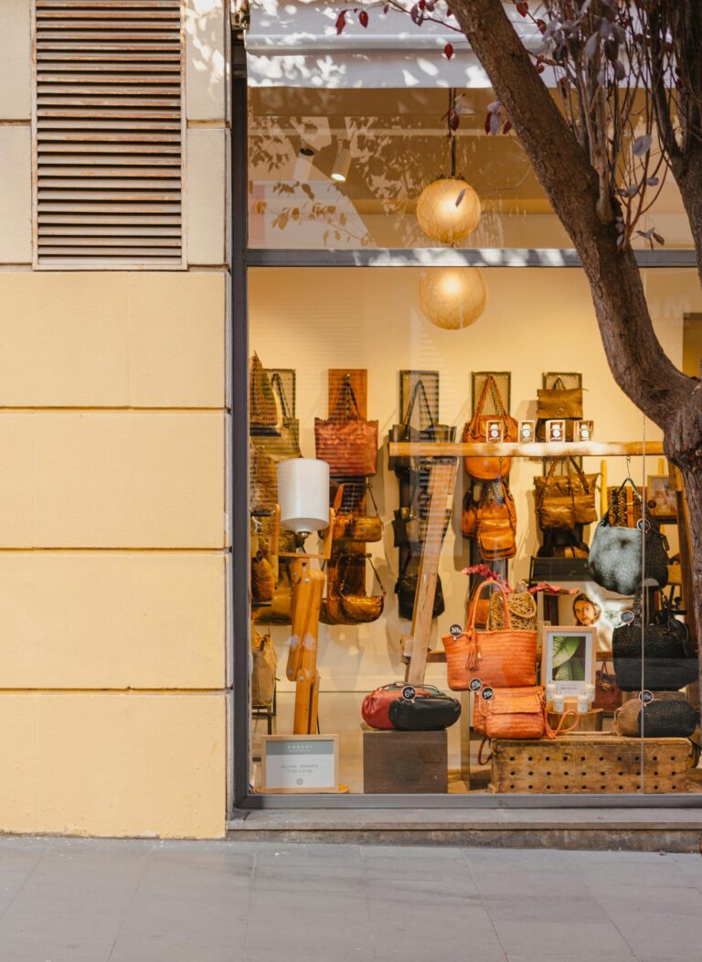 Elegant handbag store display in Barcelona, featuring a variety of stylish bags through a large glass window.