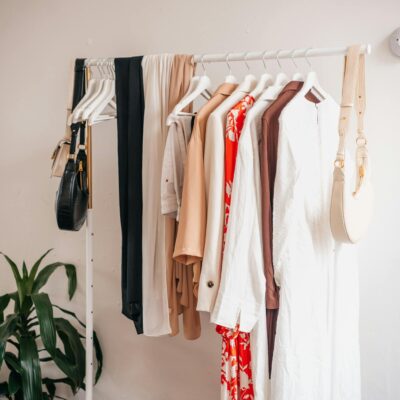 Stylish clothing rack with dresses and accessories in a boutique interior.